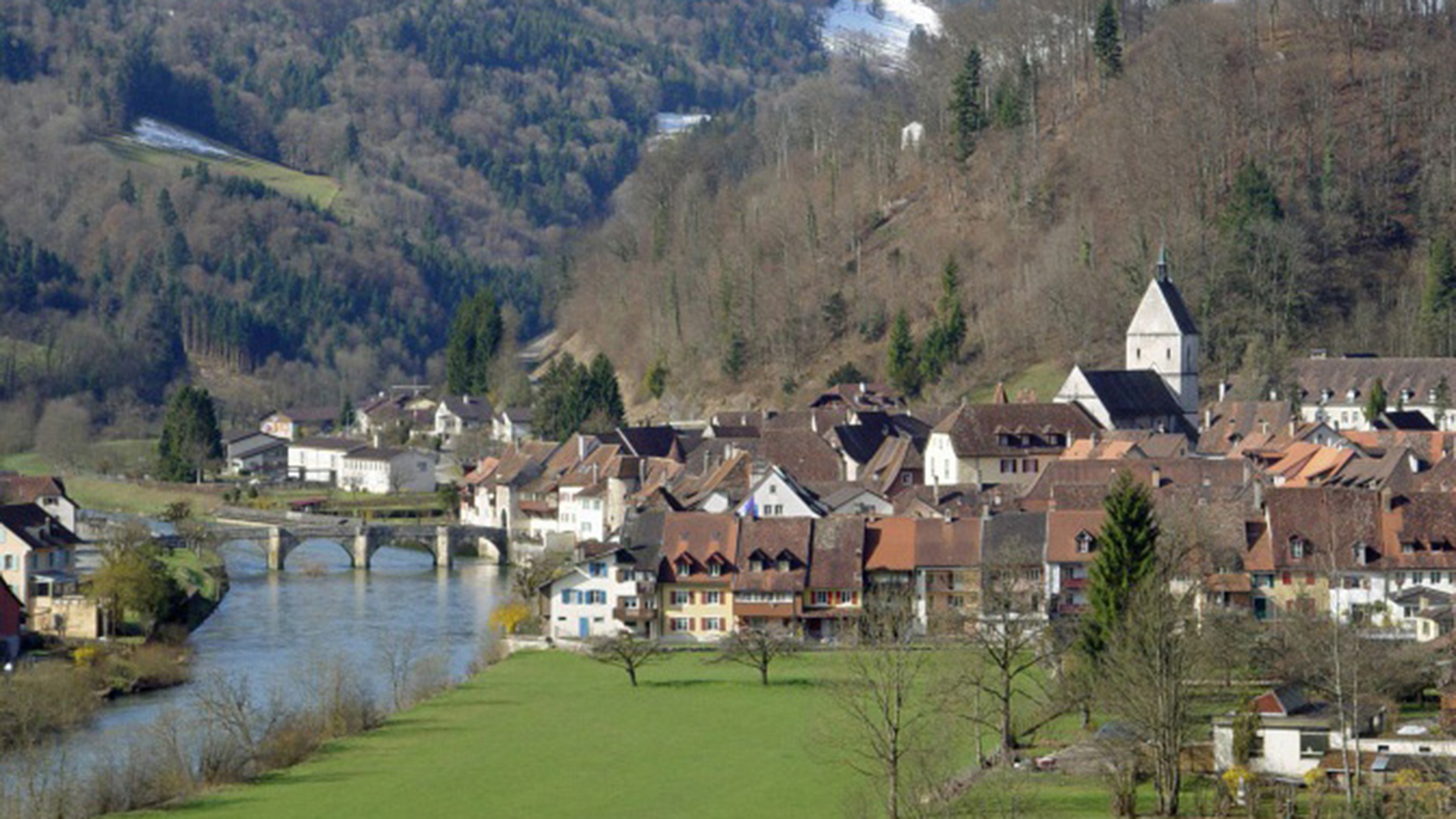 Altstadt von St. Ursanne aus einiger Entfernung, links die Brücke über den Fluss Doubs