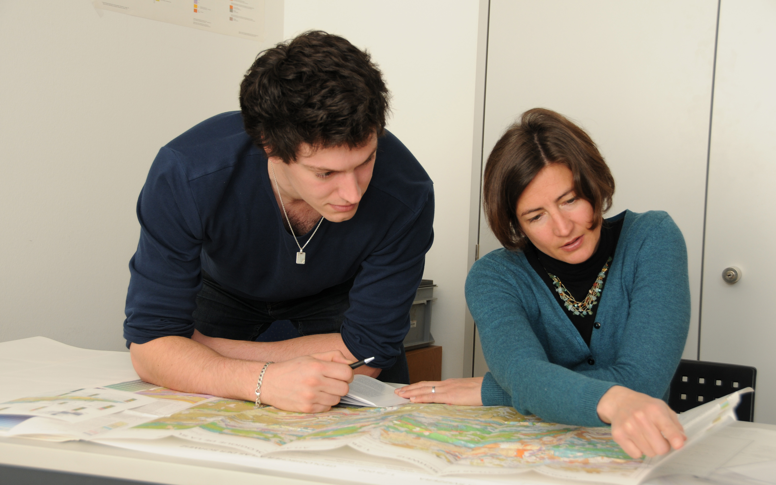 Hochschulpraktikant mit Betreuerin beim Betrachten einer geologischen Karte
