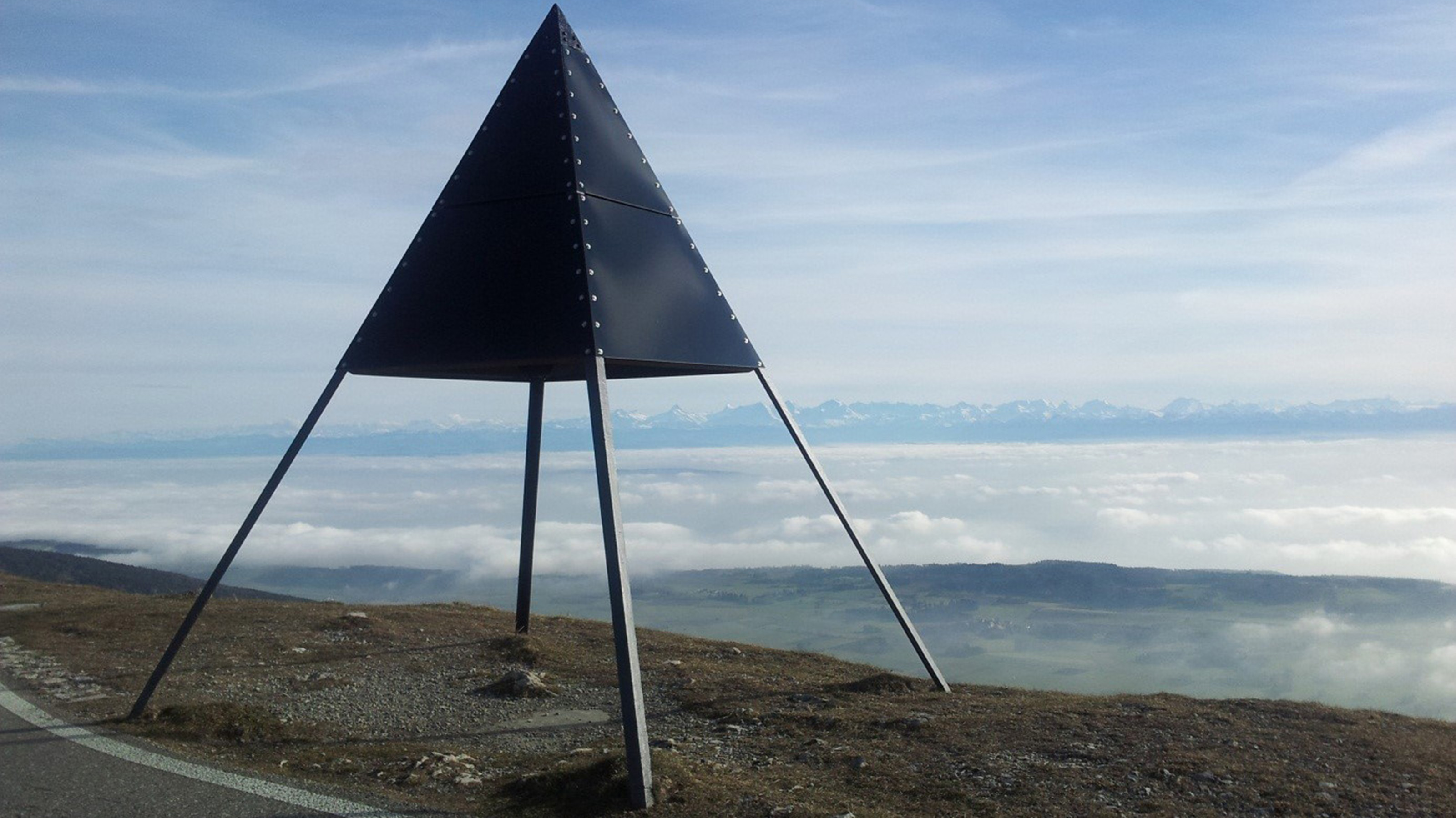 Chasseral triangulation pyramid, sea of fog and Alpine panorama in the background.