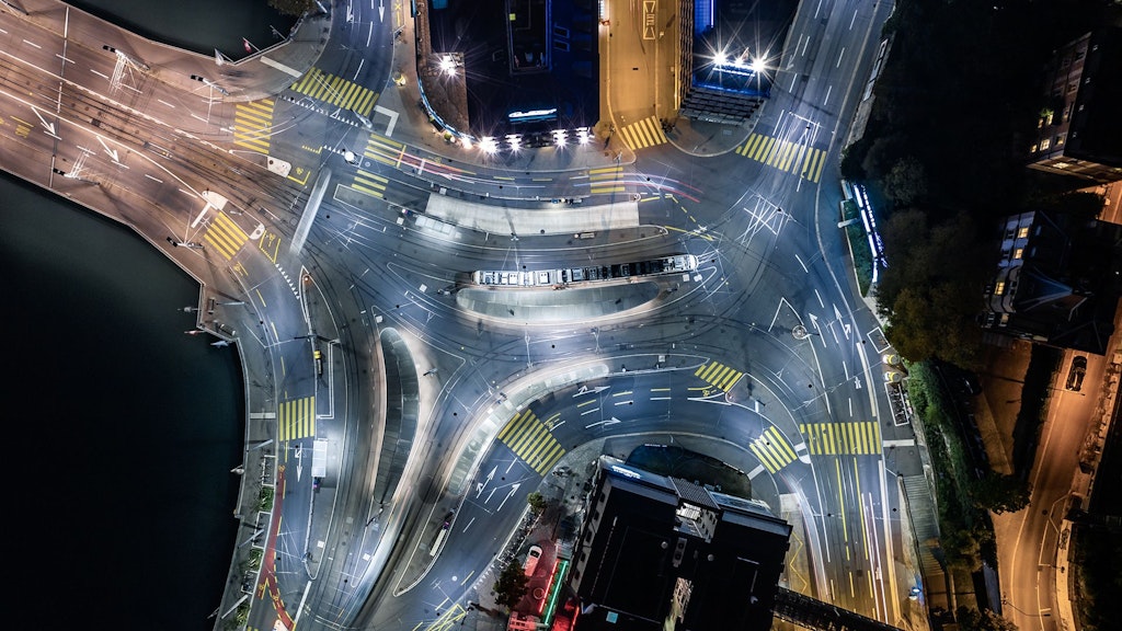 Vue aérienne nocturne d'un nœud de communication central pour tramways, bus, voitures et piétons, Zurich, Suisse.