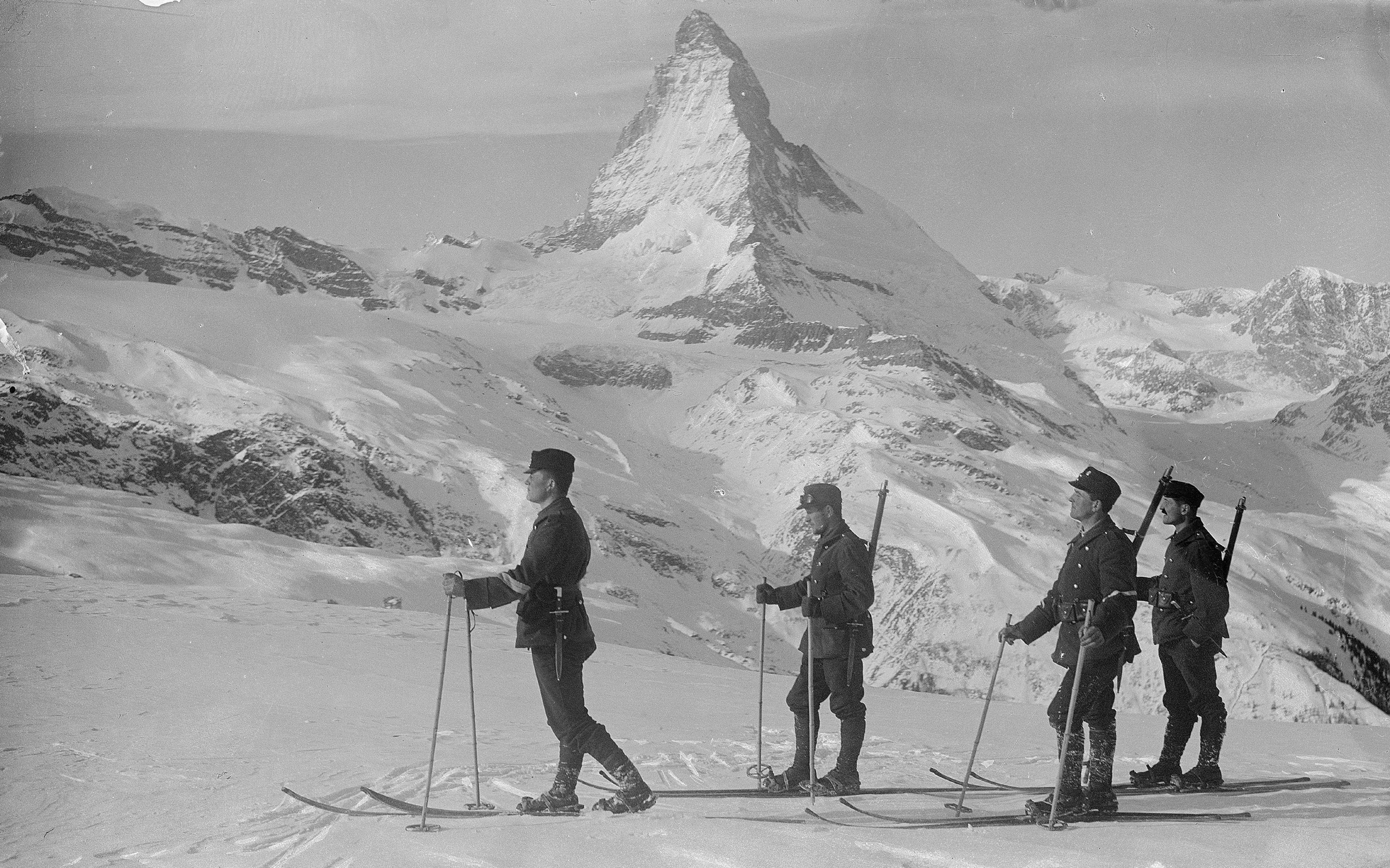 Vier Soldaten auf Skiern in den schneebedeckten Bergen. Im Hintergrund das Matterhorn.