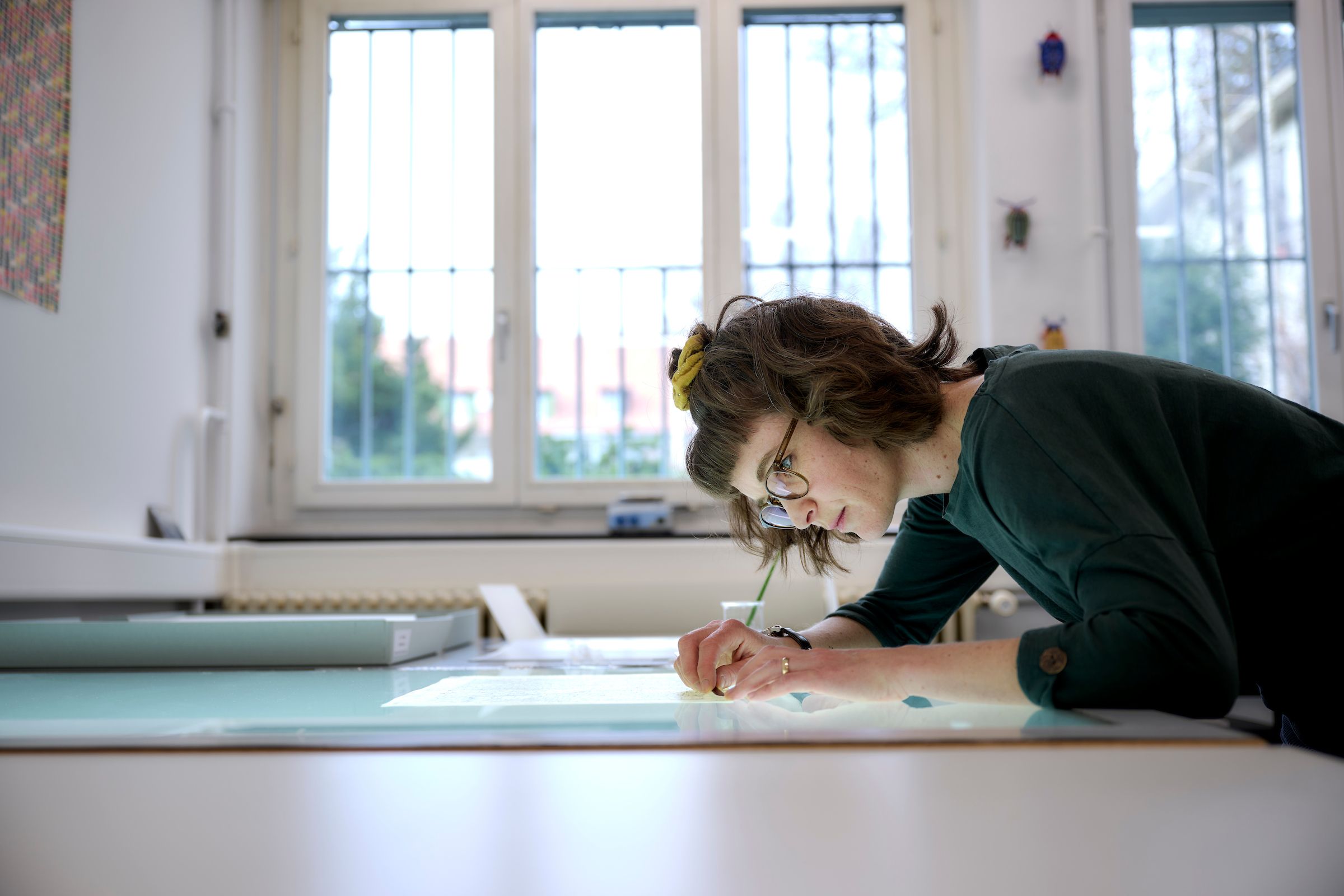 Lea Dauwalder beugt sich über eine Karte auf dem Leuchttisch