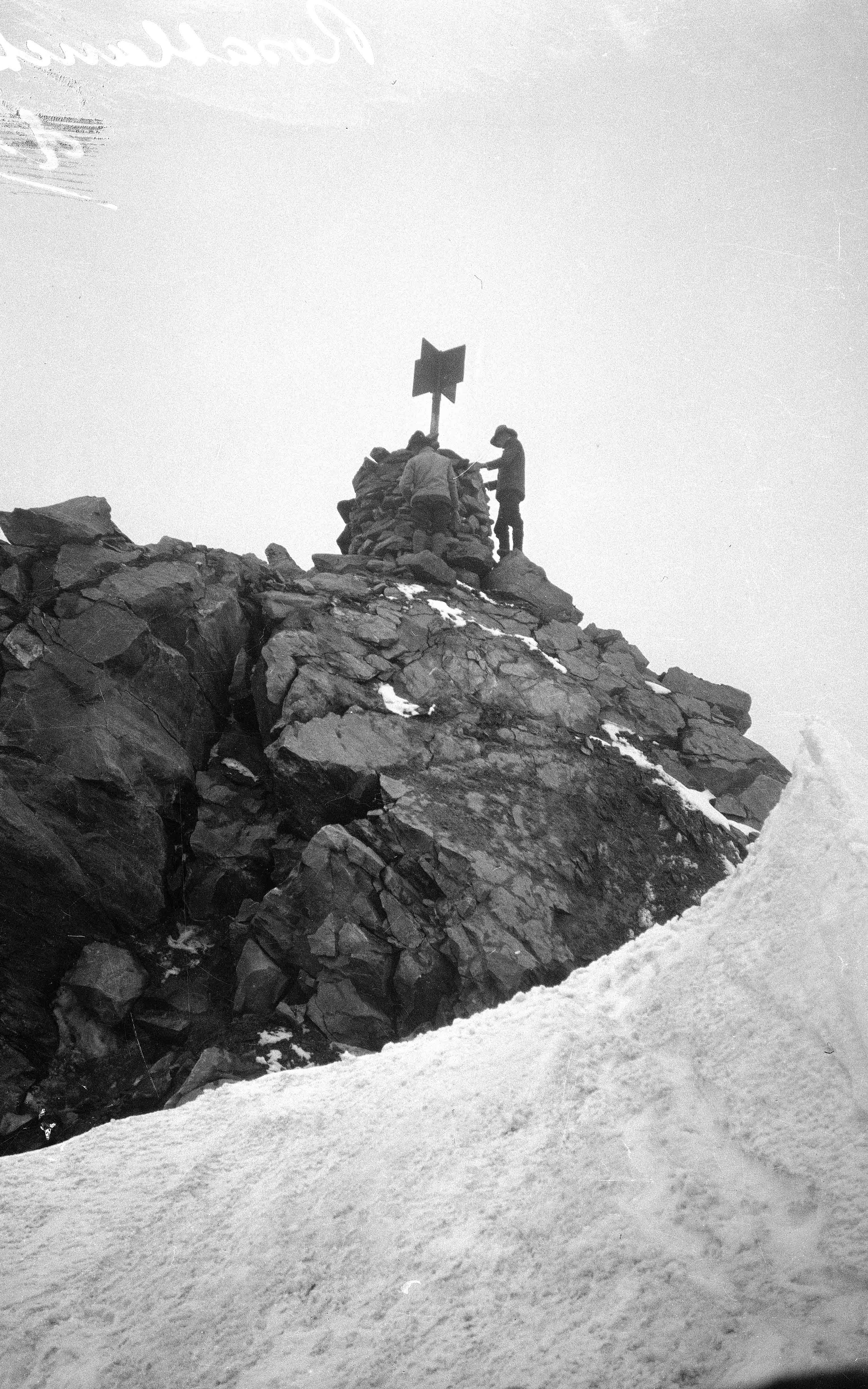 Zwei Gehilfen arbeiten am Steinmann und am Signal auf dem Gipfel der Rosablanche.