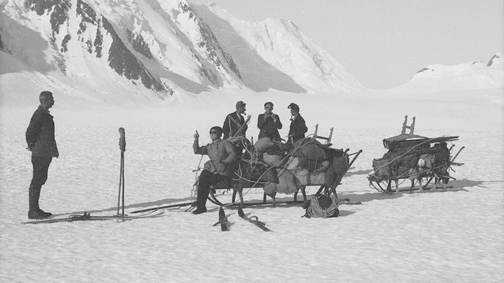 Ingenieur mit Gehilfen auf Schlitten auf dem Gletscher am Konkordiaplatz.
