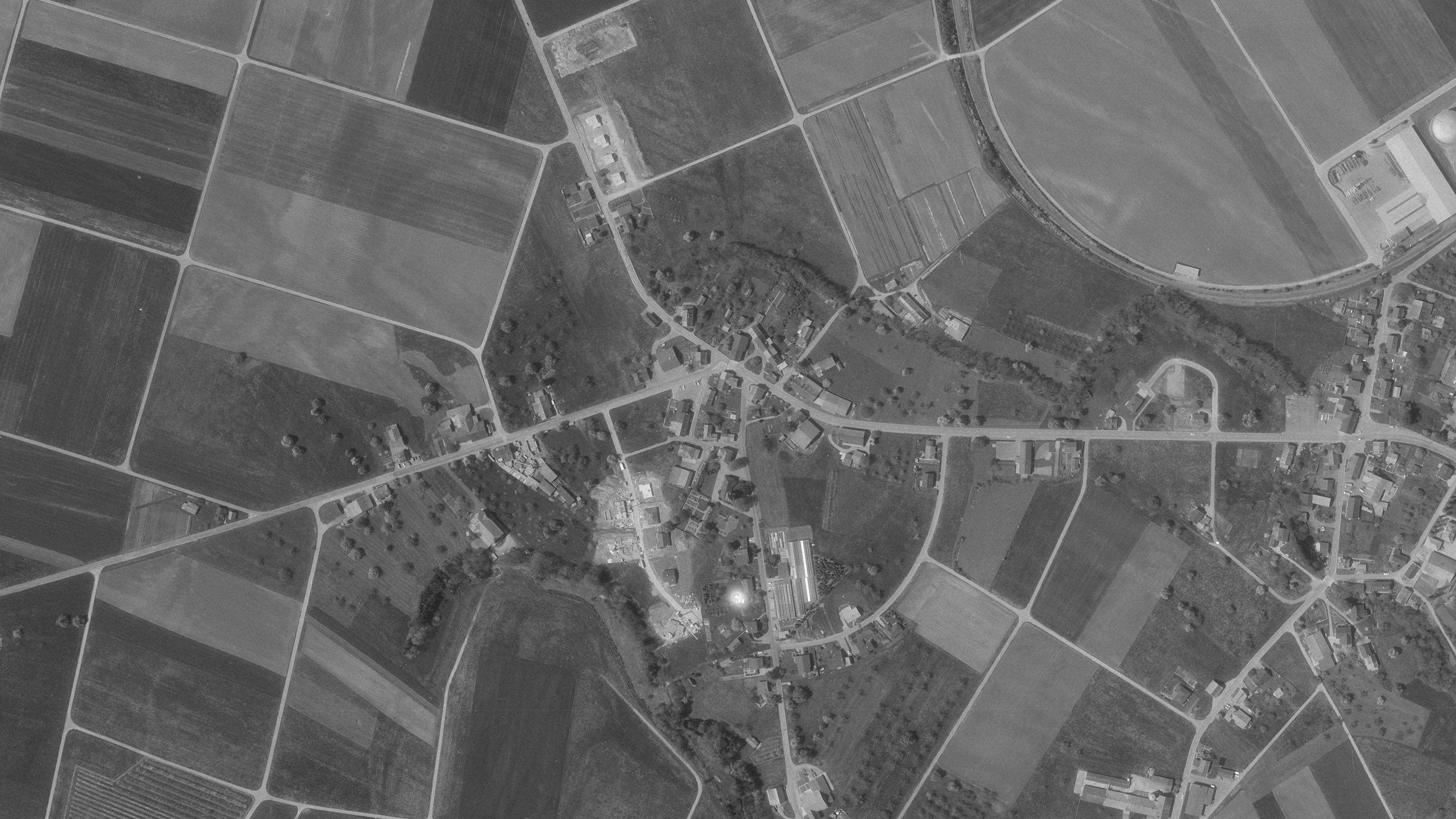 Oberhofen im Thurgau auf einem Luftbild von 1984. Das Dorf ist von Feldern umgeben, auf denen kaum mehr Obstbäume stehen.