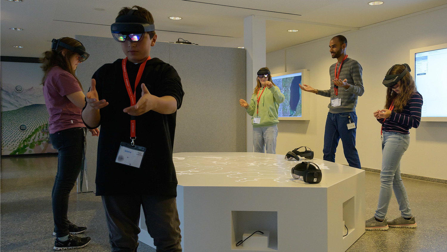 Vier Personen mit Mixed Reality Brillen, ein swisstopo-Mitarbeiter am Erklären