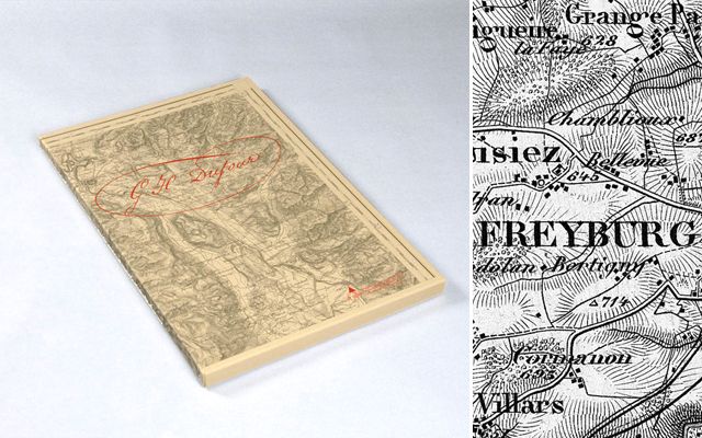 The picture shows a cardboard box on the left side, which contains the first edition of Dufour maps. A part of a Dufour map is visible on the right-hand side.