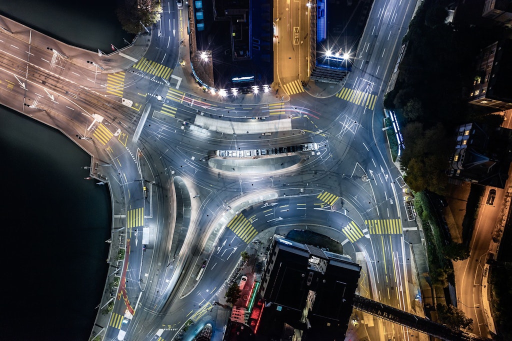Aerial view of a central transport hub for trams, buses, cars and pedestrians at night, Zurich, Switzerland.
