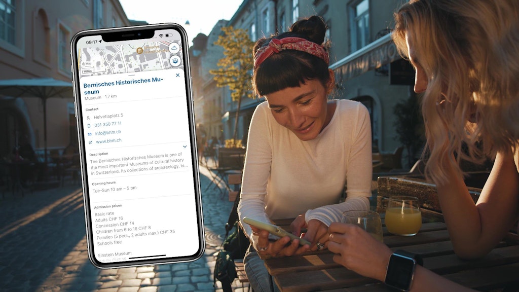 Screen showing a description of a POI with two women in a café in the background
