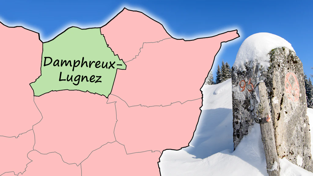 L'image montre, à droite, une borne dans un paysage enneigé. Sur la gauche, les limites communales dans la partie nord du canton du Jura, dans la zone frontalière française, avec le nom de la commune 'Damphreux-Lugnez'.