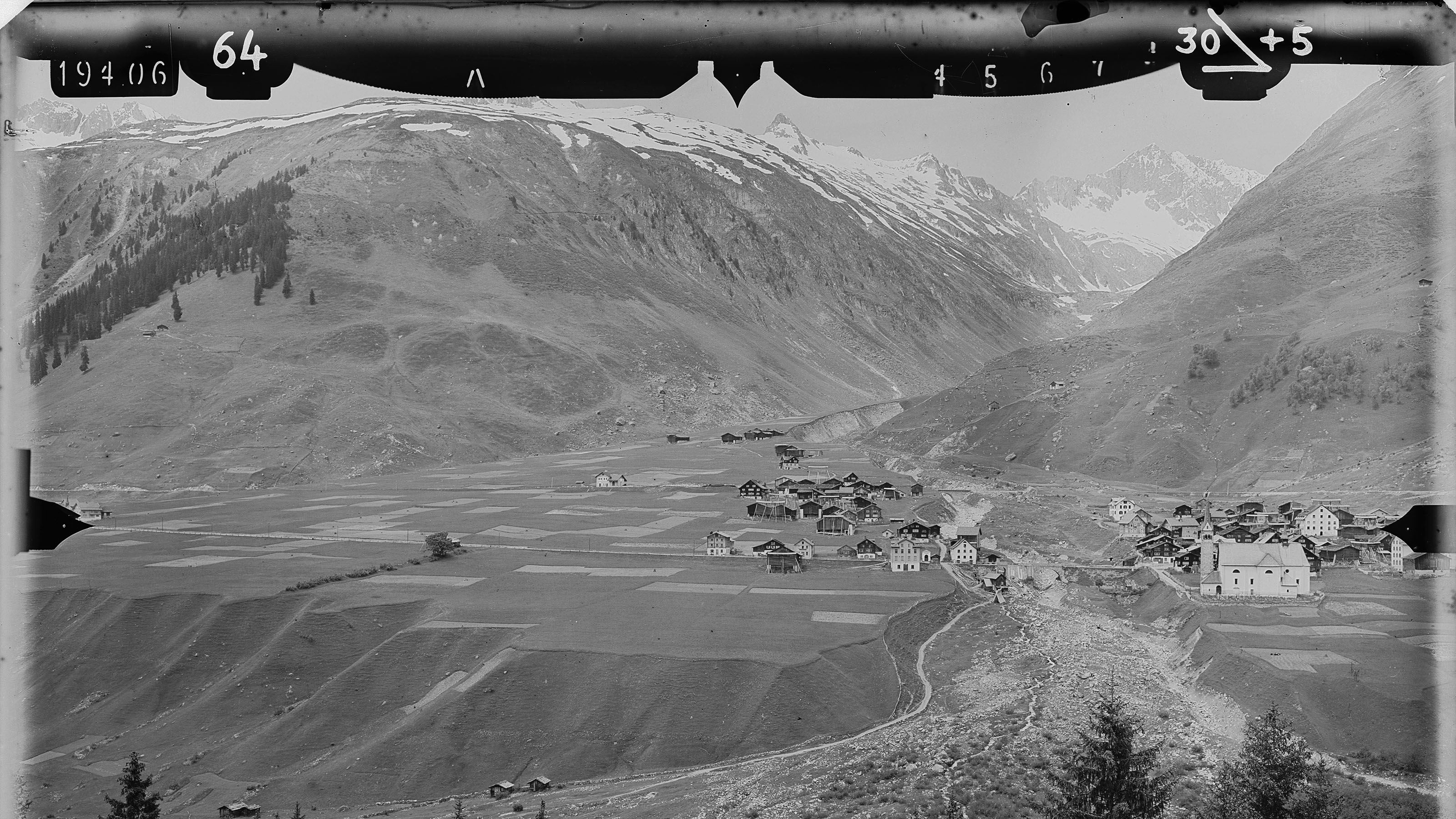 Prise de vue terrestre de Sedrun. Au premier plan, le village, à l'arrière-plan, les montagnes proches. Sur le bord de l'image, on peut voir les marques du cadre de l'image de mesure.