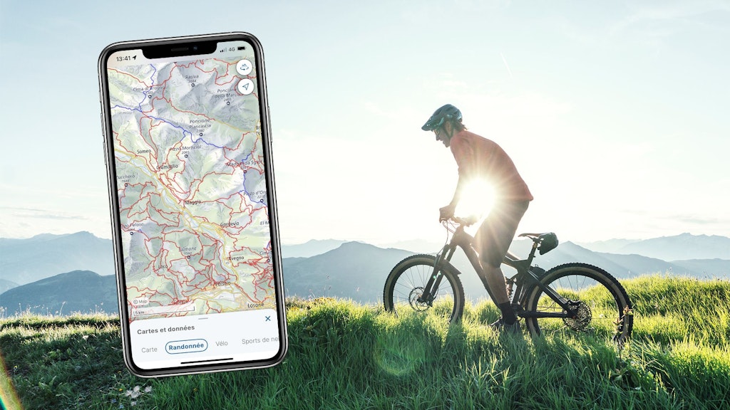 Carte de base avec thème de la randonnée dans l'application swisstopo, avec une personne à vélo en arrière-plan