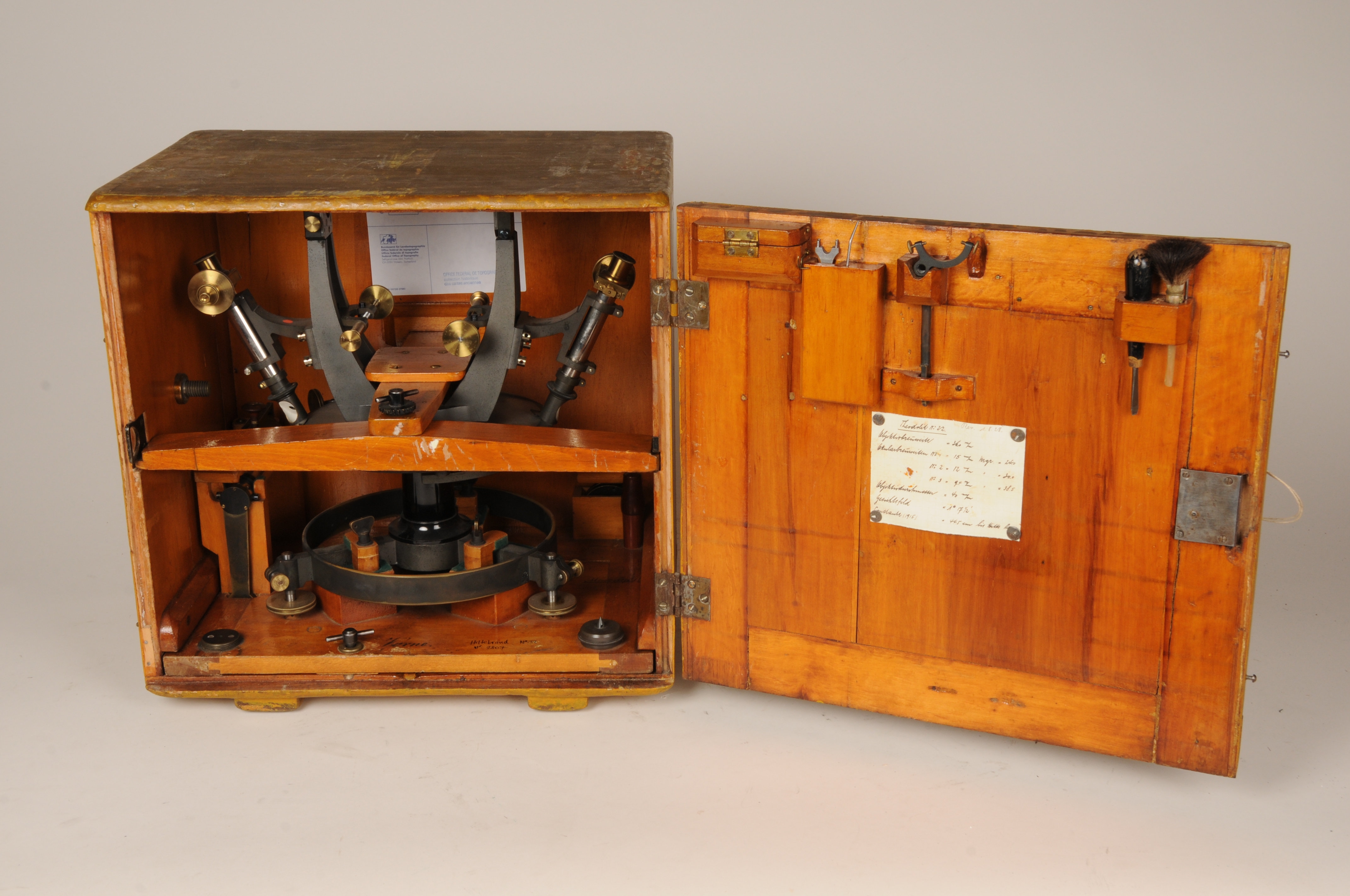 Caisse en bois dans laquelle se trouve une partie du théodolite démonté. Tout est rangé de manière très compacte.