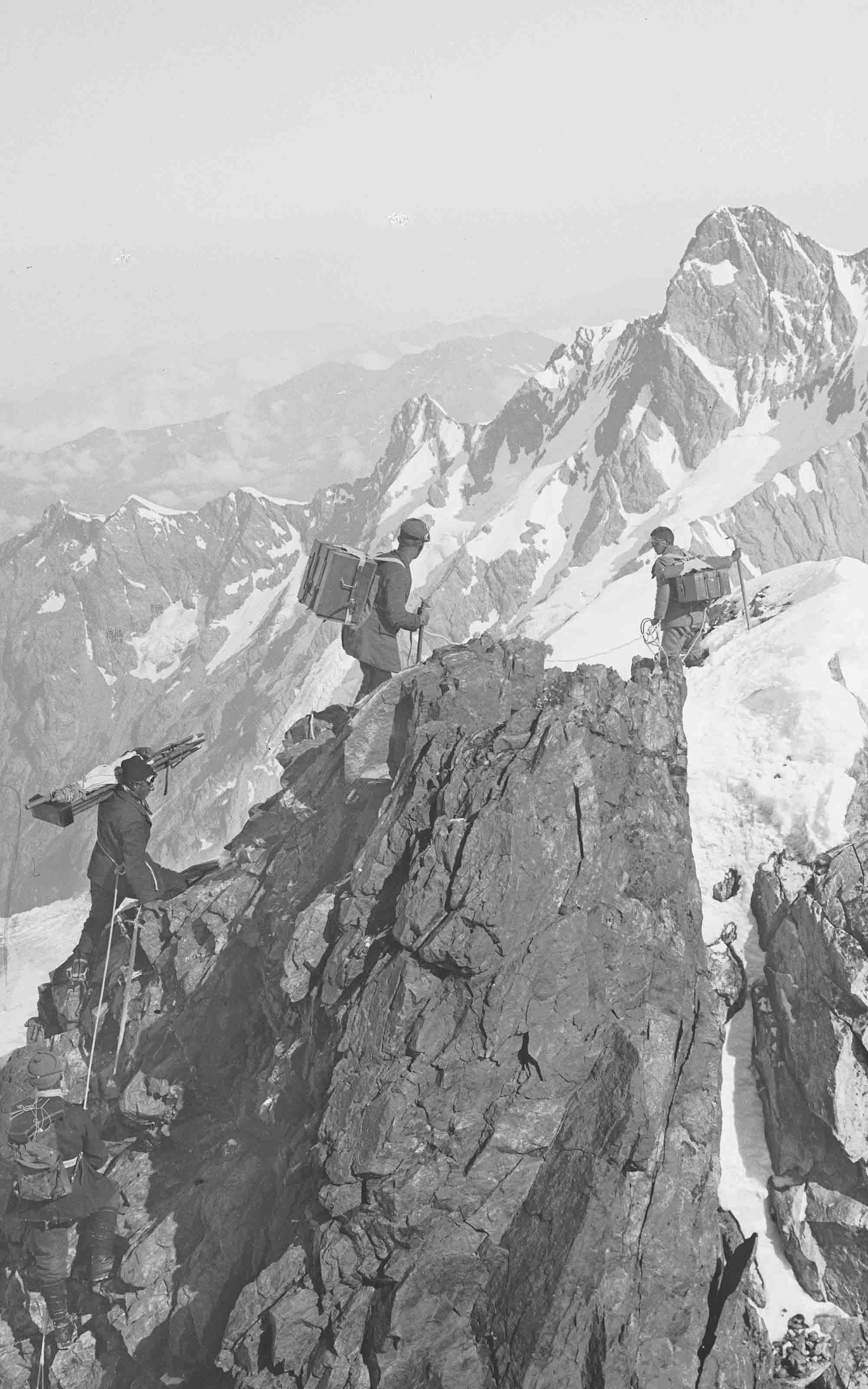 Une équipe de géomètres sur le Finsteraarhorn. Les caisses d'emballage dans lesquelles se trouvent les instruments ont été attachées sur le dos des assistants.