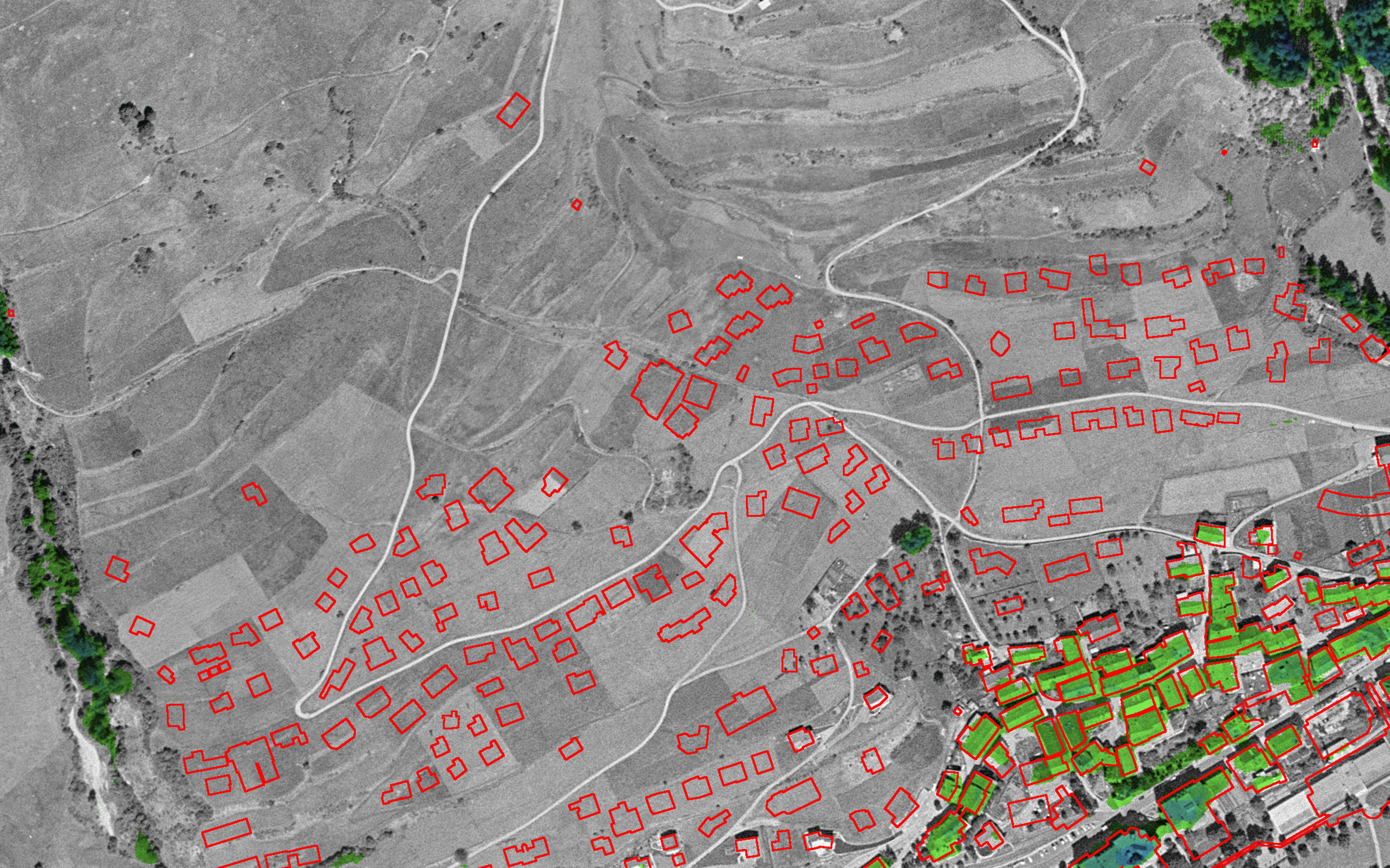 Extrait de la mosaïque d'orthophotos historiques SWISSIMAGE HIST. Scuol en 1961. L'analyse superposée montre avec des contours rouges où se trouvent des maisons à Scuol aujourd'hui et pas à l'époque.