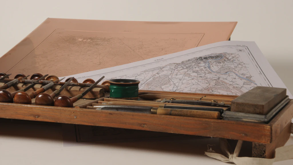 Photographie du marteau, du poinçon et d'autres outils de la gravure sur cuivre.