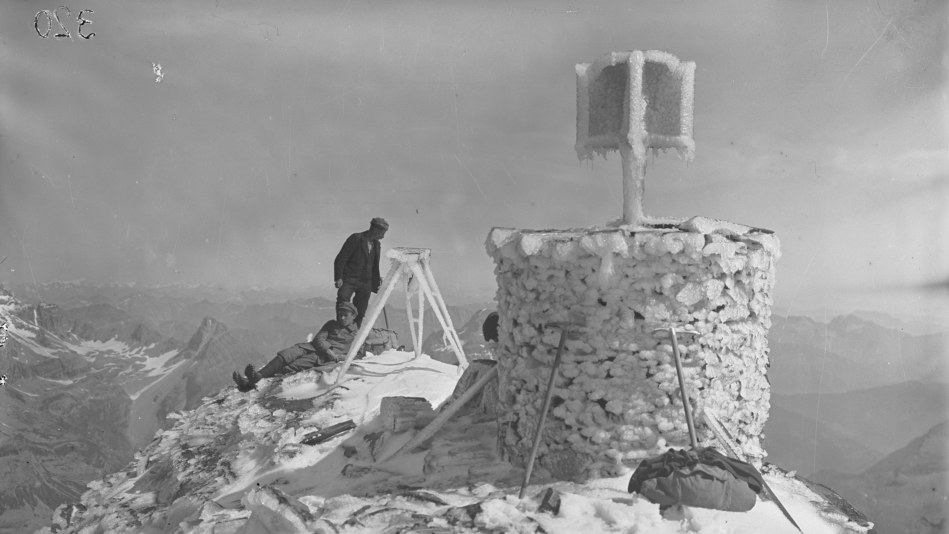 Signal recouvert de givre dans l'homme de pierre du Wasenhorn. Un géomètre se tient à côté.