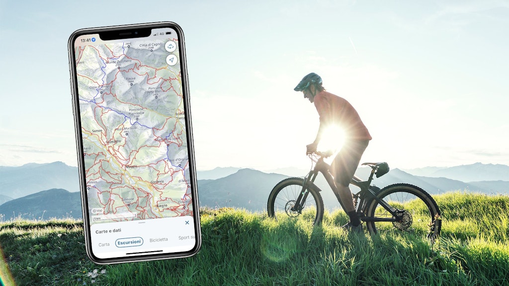 Schermata Base Map con tema escursionismo nell'app swisstopo con una persona in bicicletta sullo sfondo